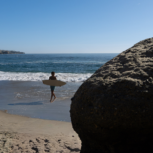 Boy holding a surfboard on the beach