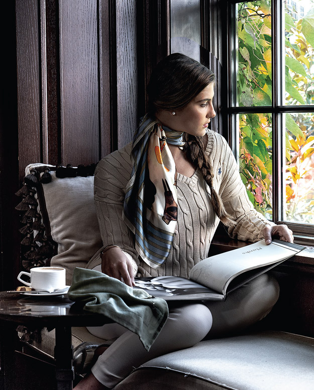 Woman sitting by a window, reading a book