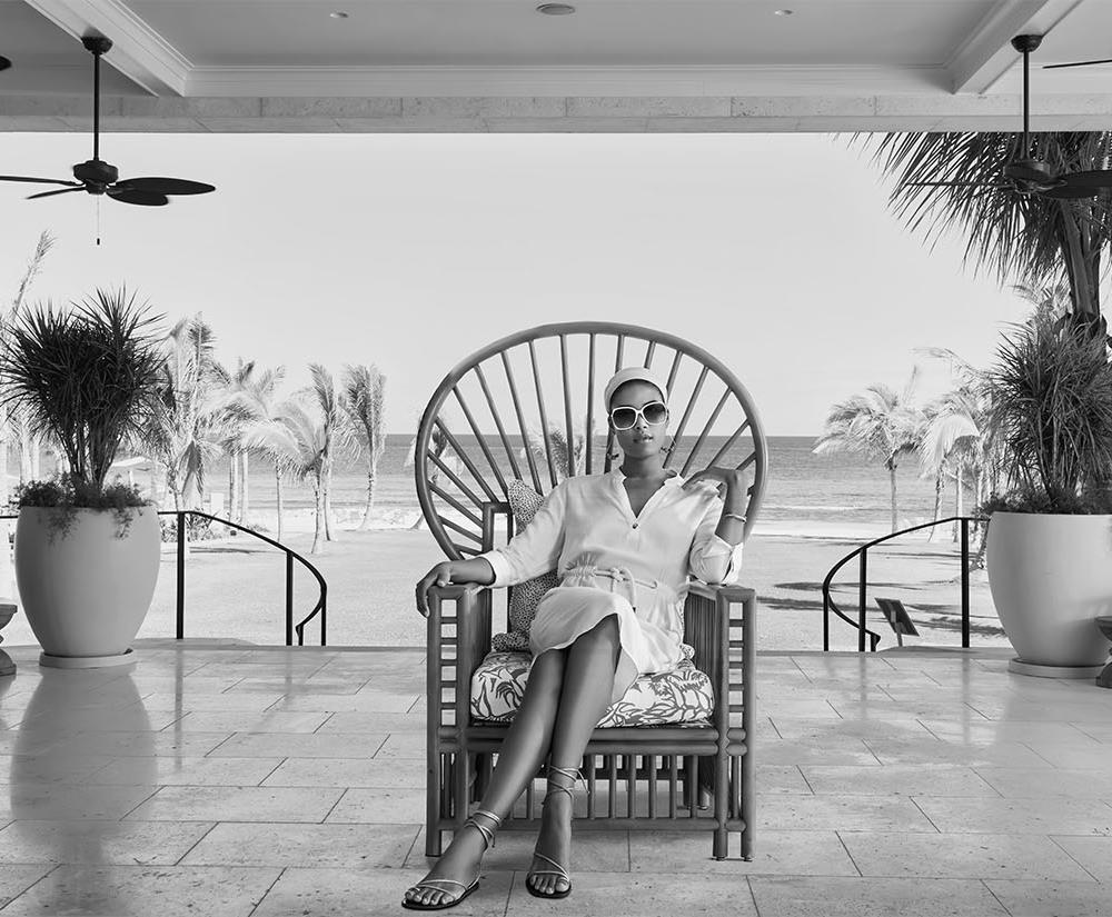 Stylish woman sitting in a chair beach view background